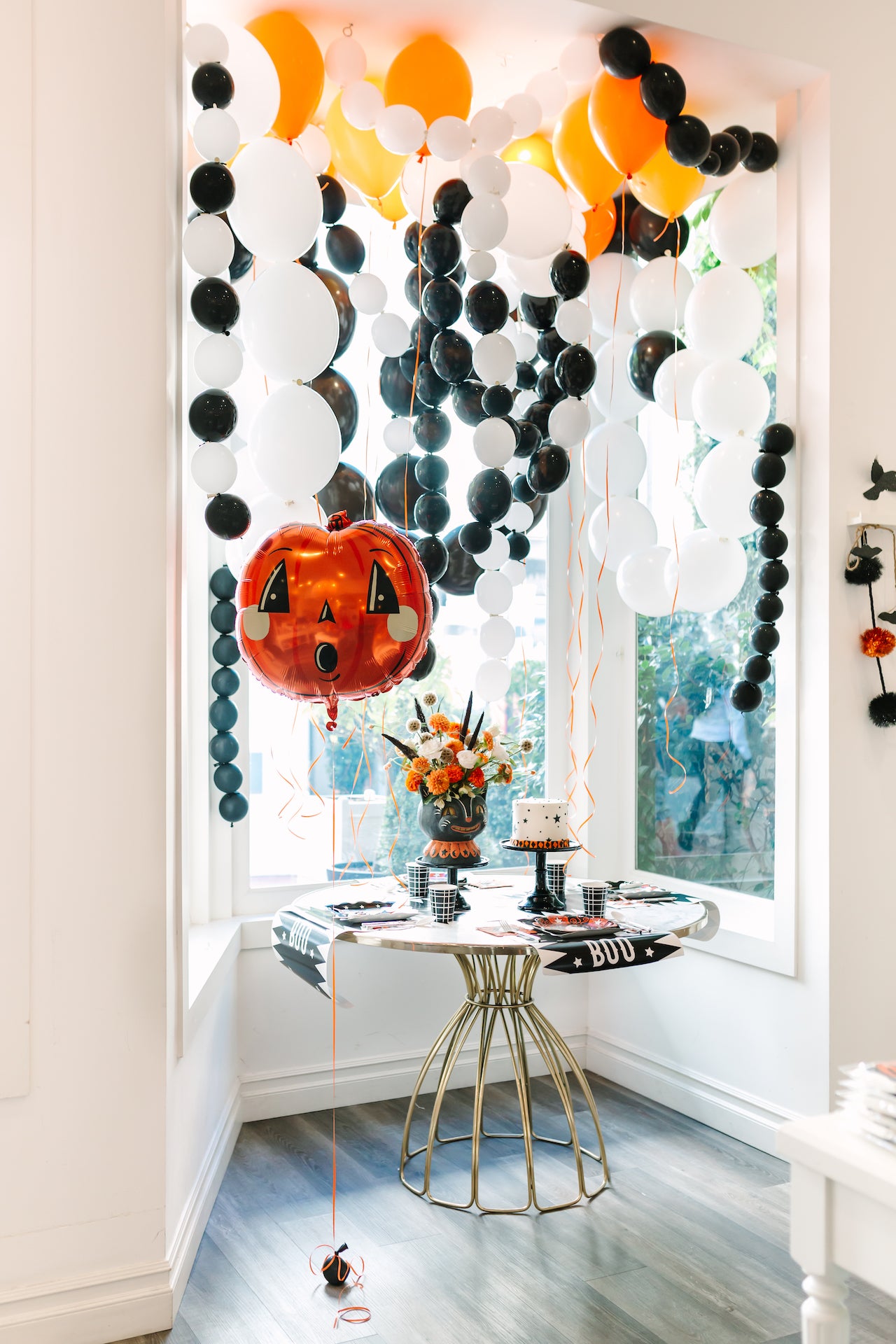Vintage Halloween party table with balloon garlands.