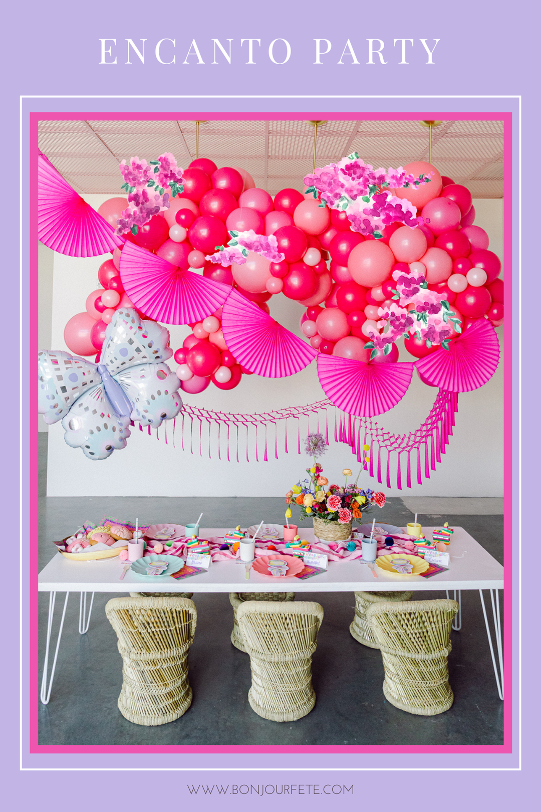 Colorful Encanto birthday party decorations featuring tropical flowers, butterfly motifs, and vibrant fiesta tablescape