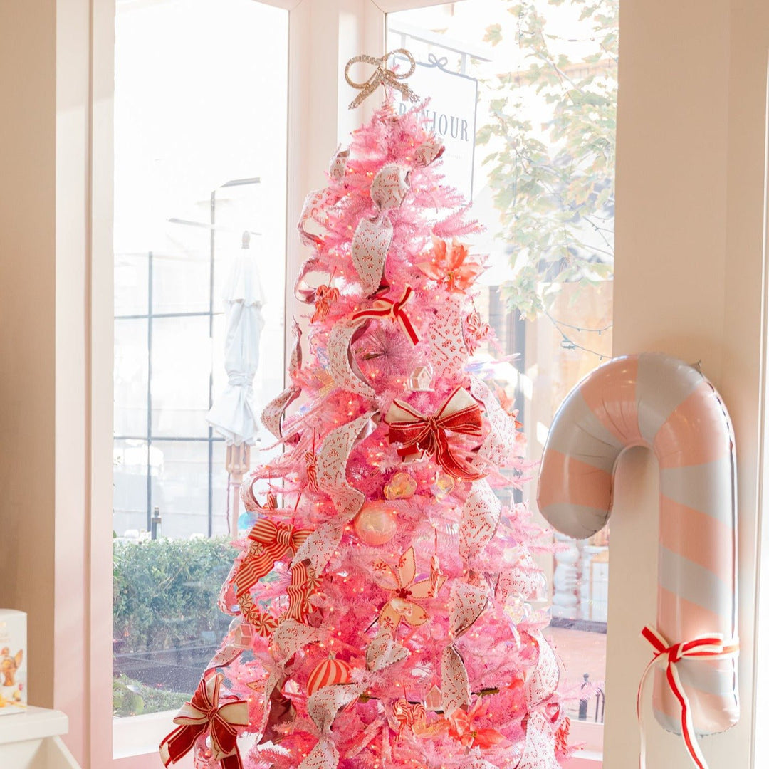 Pink Christmas tree with jeweled tree topper, as well as other tree skirts and stockings from Bonjour Fete