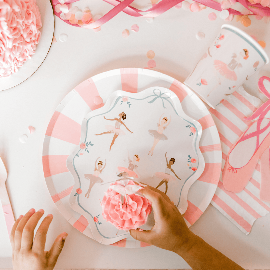 Ballerina party table with ballet-themed plates, soft pink balloons, and decorations for a dance birthday or recital.