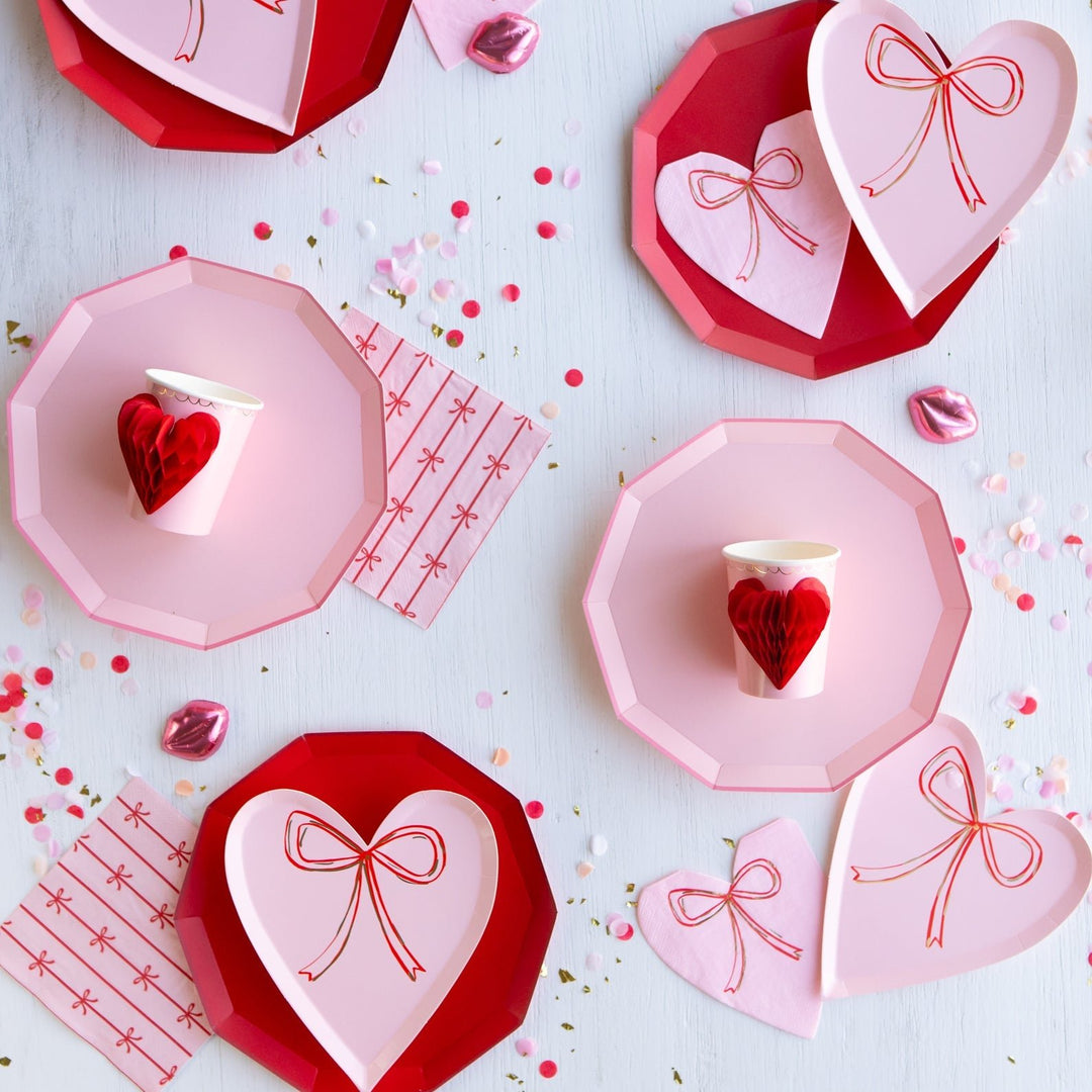 Bow and coquette party table with ribbon decorations, bow accents, and feminine tableware for a birthday or shower.
