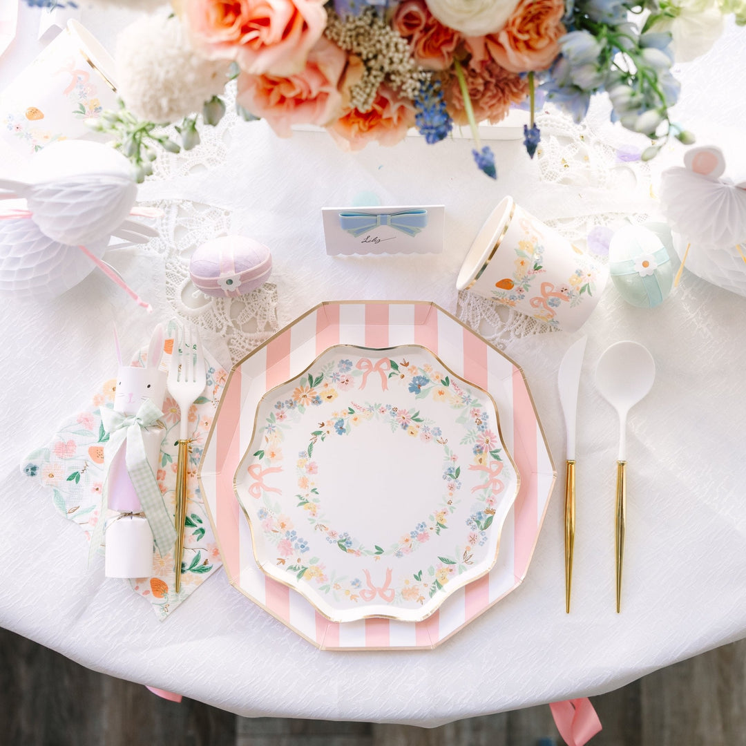 Elegant floral cups styled in a complete Easter party table setting with napkins, garland, and floral backdrop