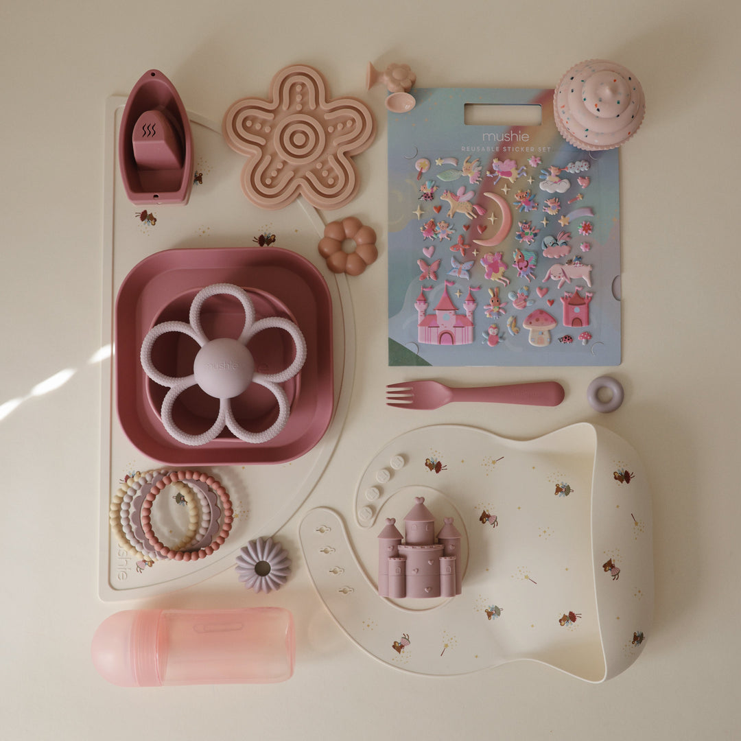 Mushie baby toys flatlay with silicone teethers, bath toys, and gift sets for baby showers and new-baby gifts.
