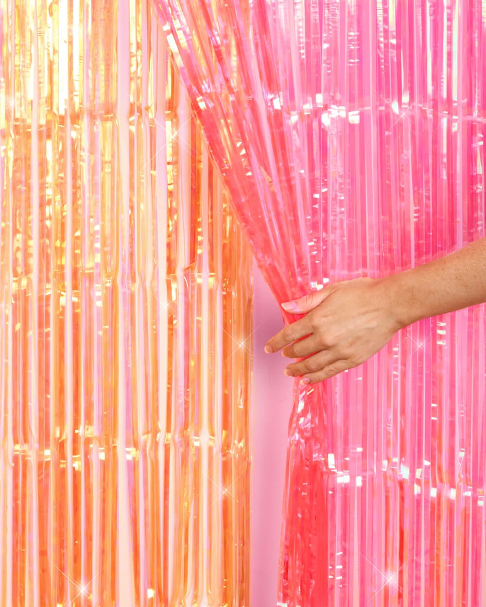 Pink and orange sunset fringe curtains hung side by side covering a full wall