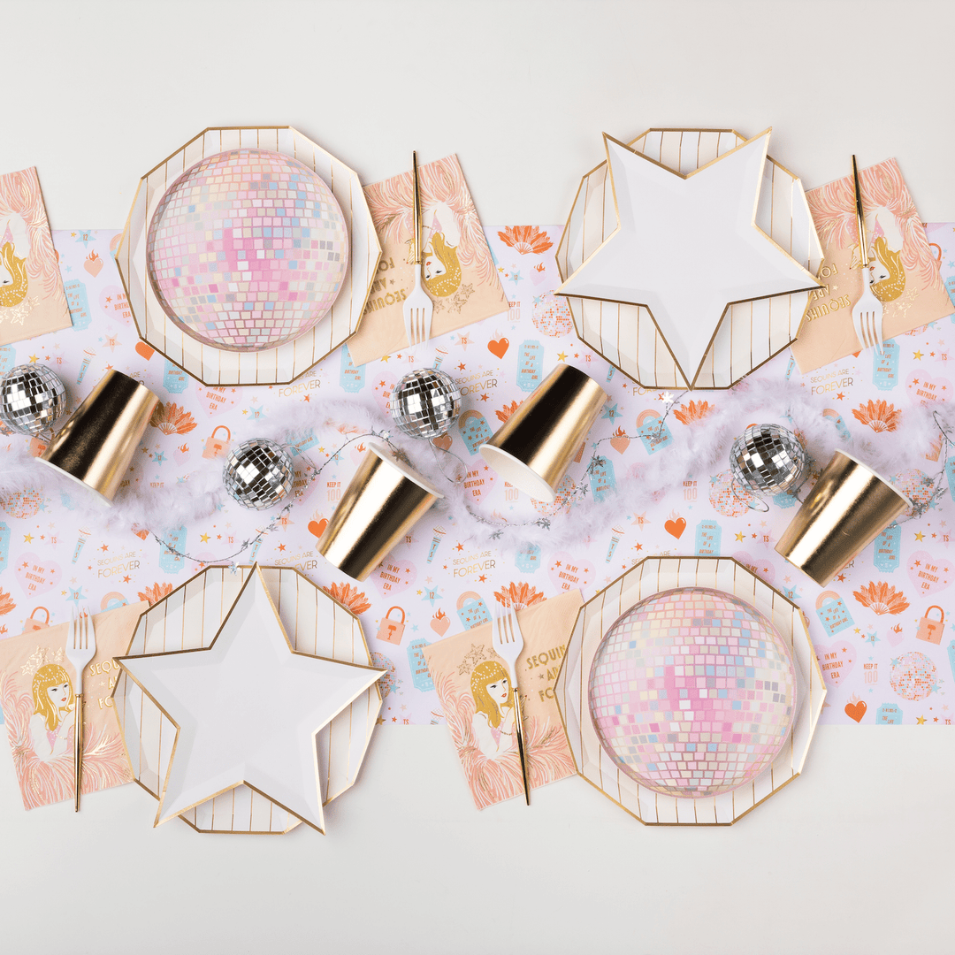 Glam party table with sequin showgirl napkins, disco ball plates, star plates, and gold cups