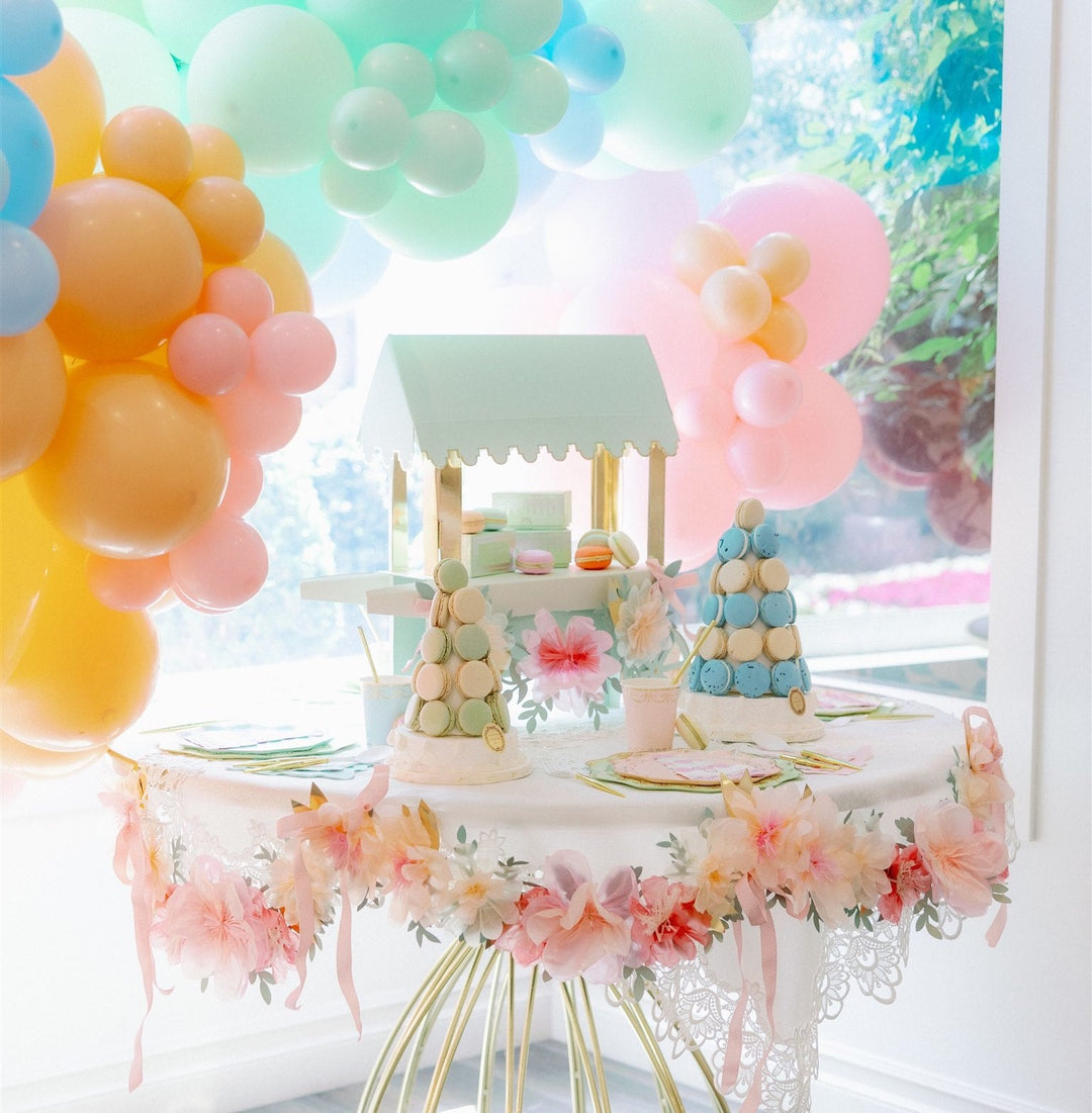 Tea party table set with floral plates, napkins, and cups for a birthday or bridal shower.