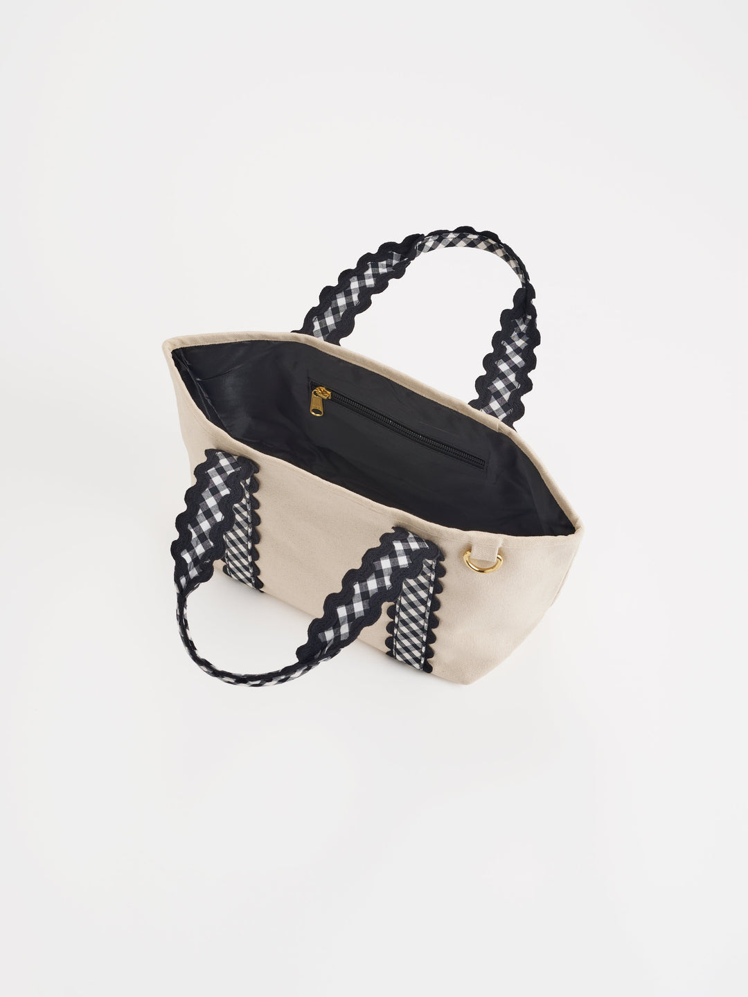 Beige handbag with black gingham handles on a white background