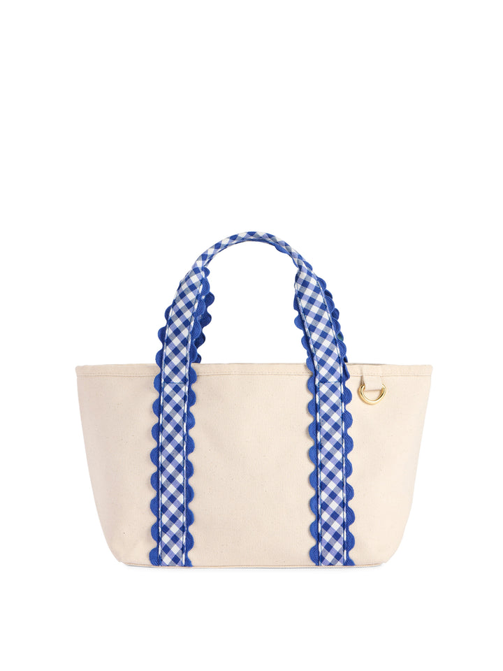 An off-white canvas tote bag with blue and white gingham patterned handles trimmed in blue scalloped edges, featuring a small gold metal D-ring on the side.