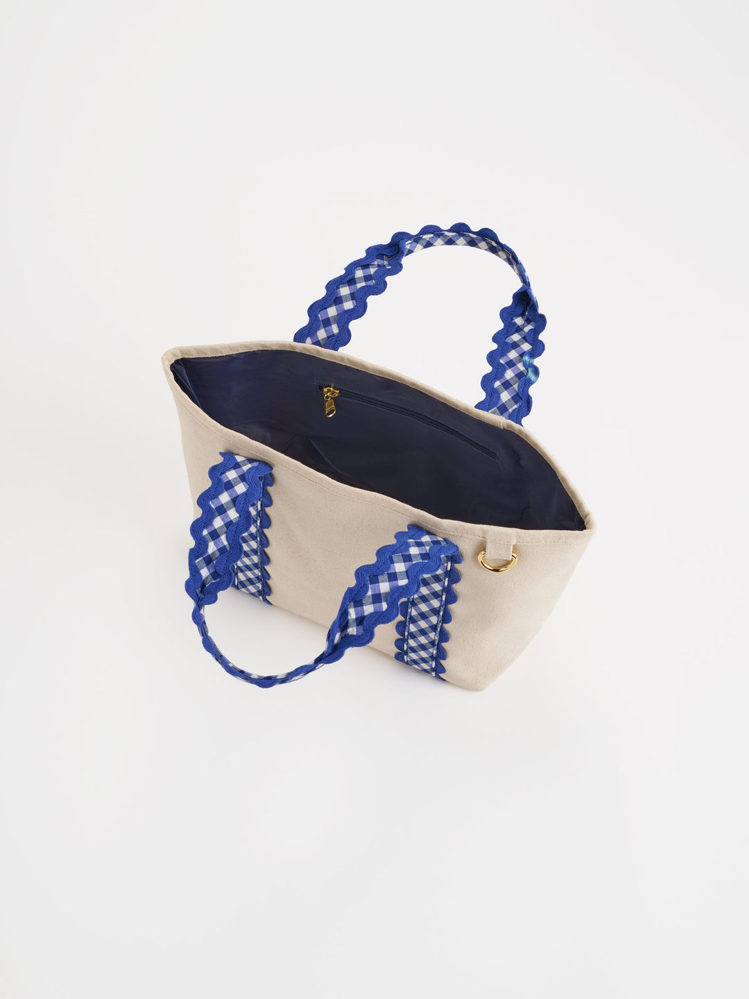 Beige tote bag with blue gingham handles on a white background