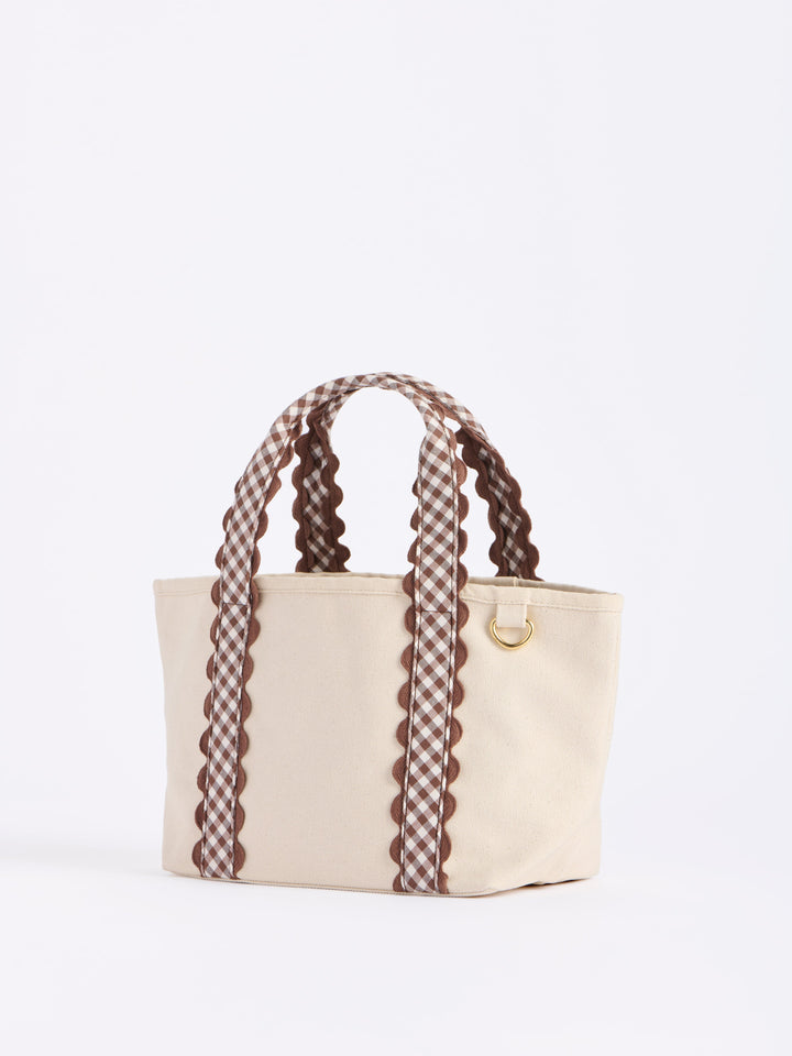 Beige handbag with plaid handles on a white background