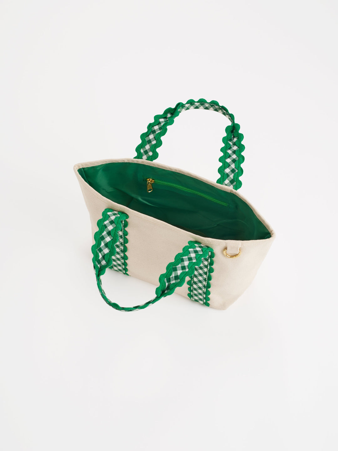 A cream canvas tote bag with vibrant green woven handles and a green interior, shown on a plain white background.
