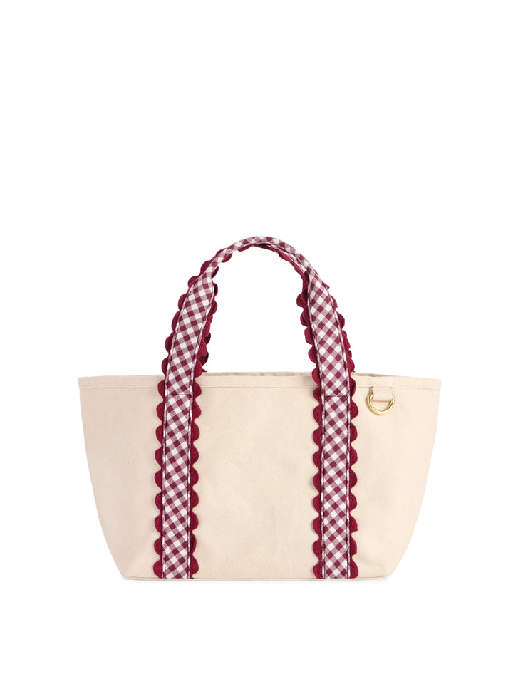 Beige tote bag with red and white checkered handles on a white background