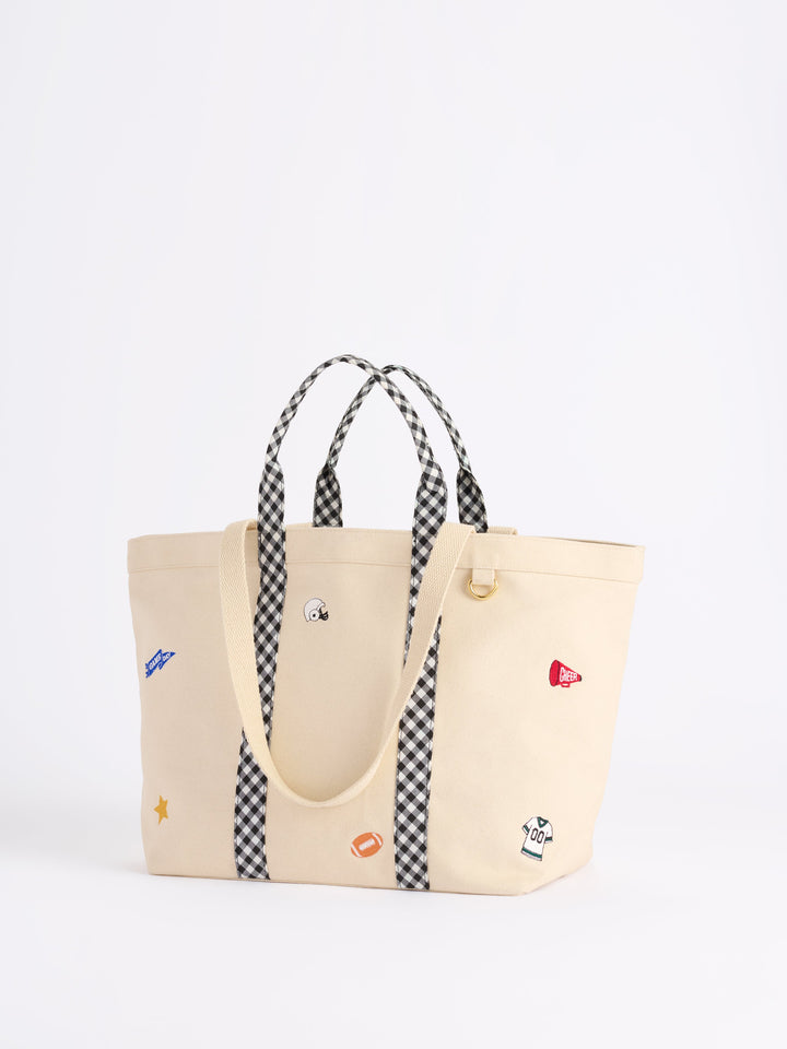 Beige tote bag with checkered straps on a white background