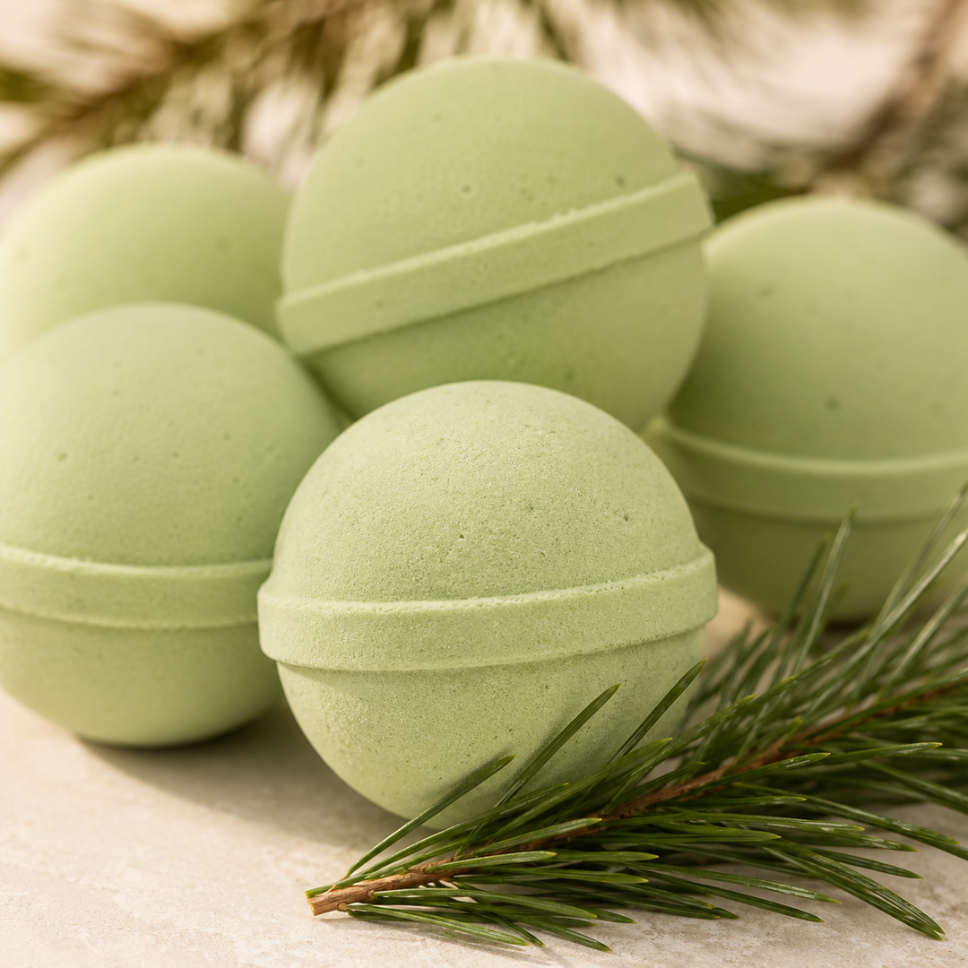Close-up of sage green mini bath bombs stacked with a pine sprig, fresh forest scent for a holiday spa night