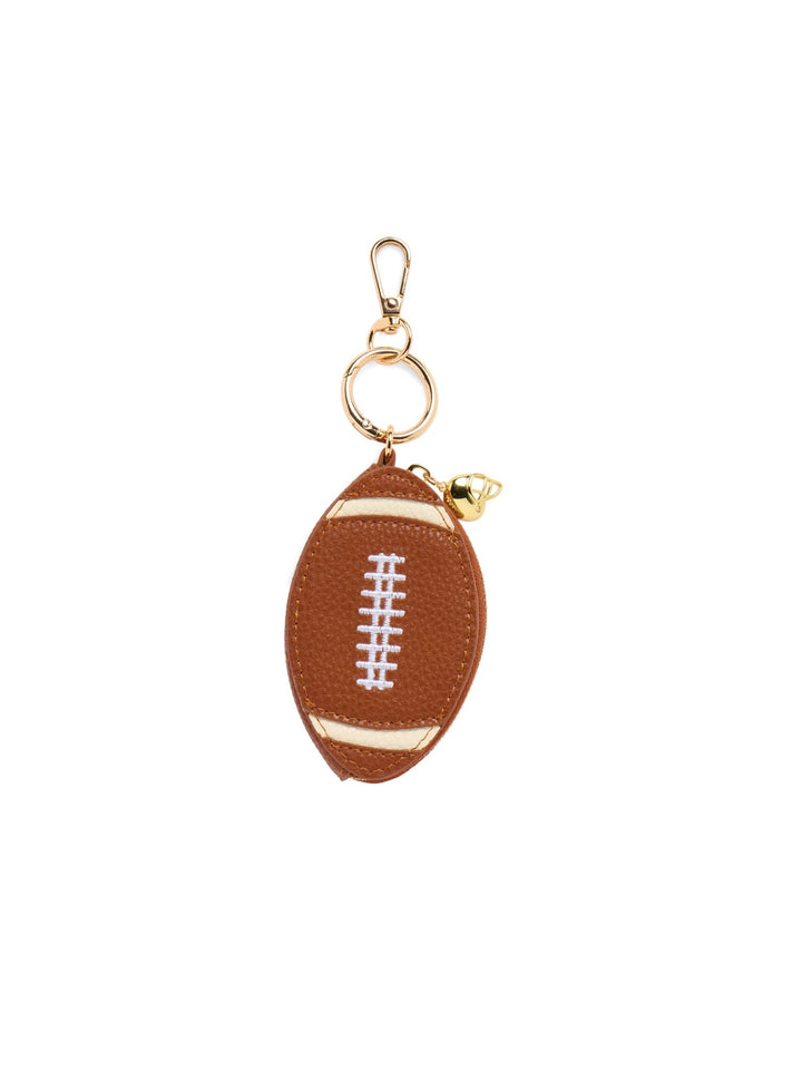 A small football-shaped keychain pouch in brown faux leather with white laces and gold-tone hardware, shown on a plain white background.