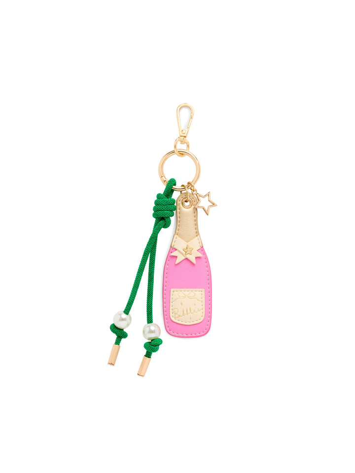 A pink champagne bottle charm keychain with a green cord, gold-tone metal hardware, and small pearl beads on a plain white background.