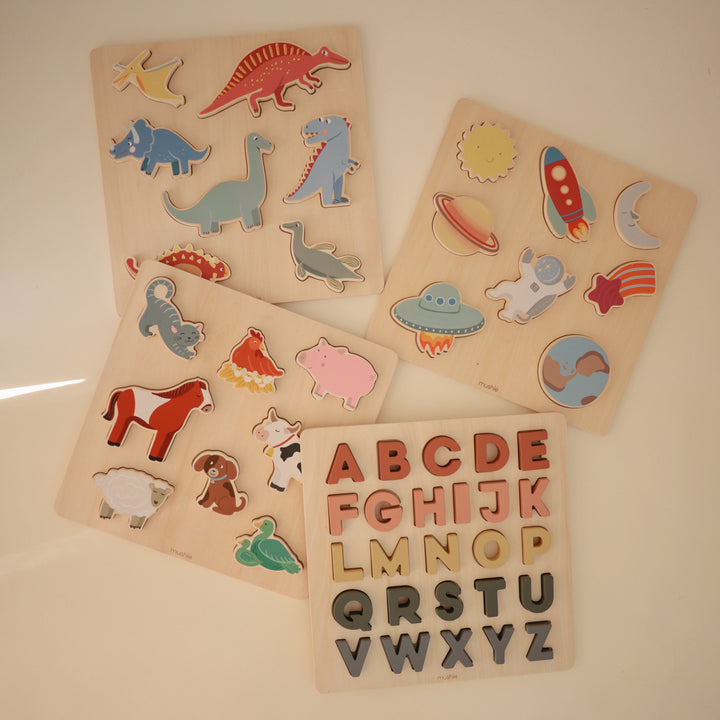 Flat lay of Mushie wooden puzzles in several designs