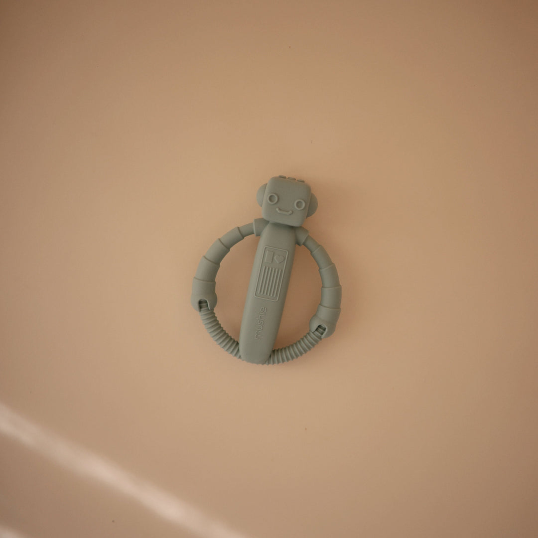 Flat lay styling of the Mushie silicone rattle teethers