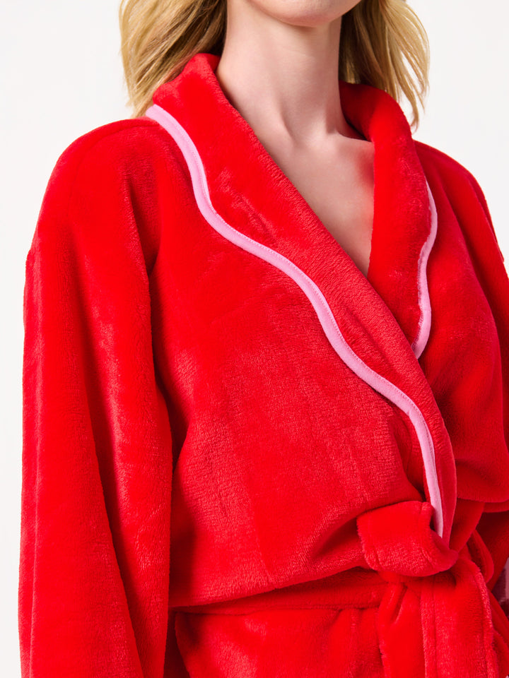 Close-up of the pink scalloped collar trim on the red robe