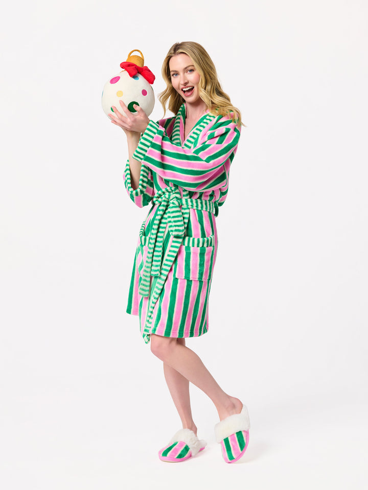 Woman in a pink and green stripe robe holding a snowman ornament