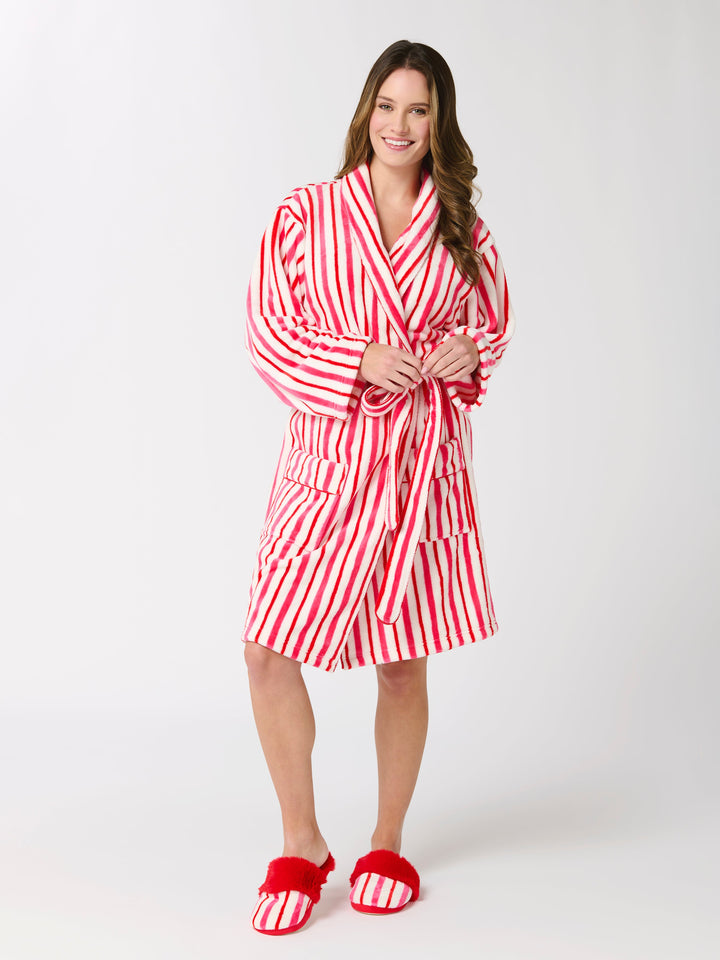 Woman in a red and white candy stripe robe and red faux fur slippers