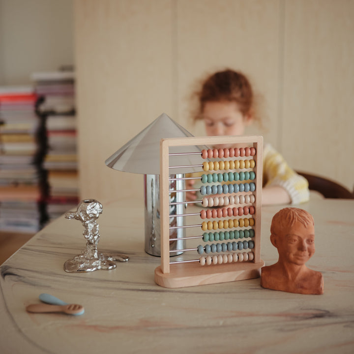 Child playing with the Mushie wooden abacus