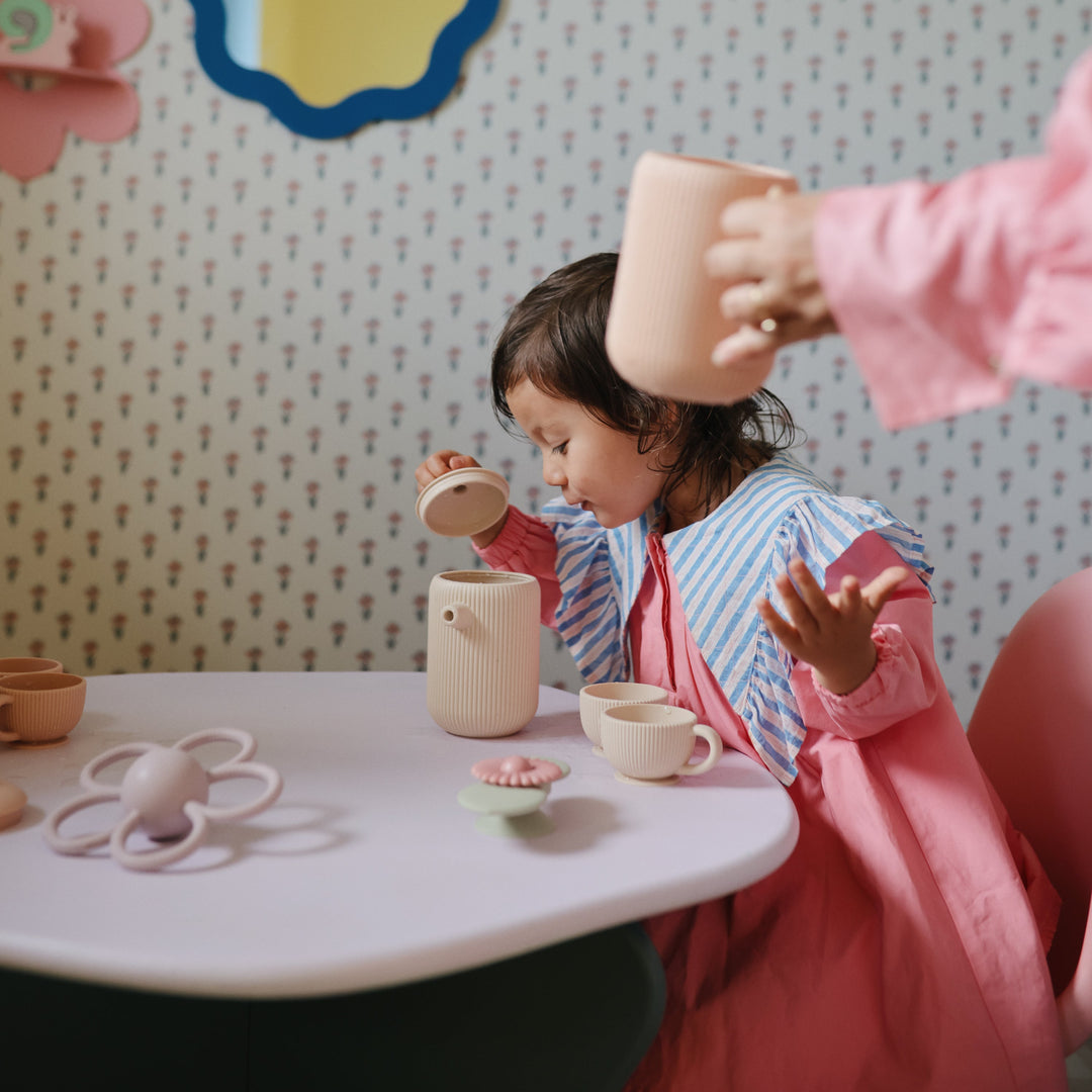 Child playing with the Mushie silicone tea set