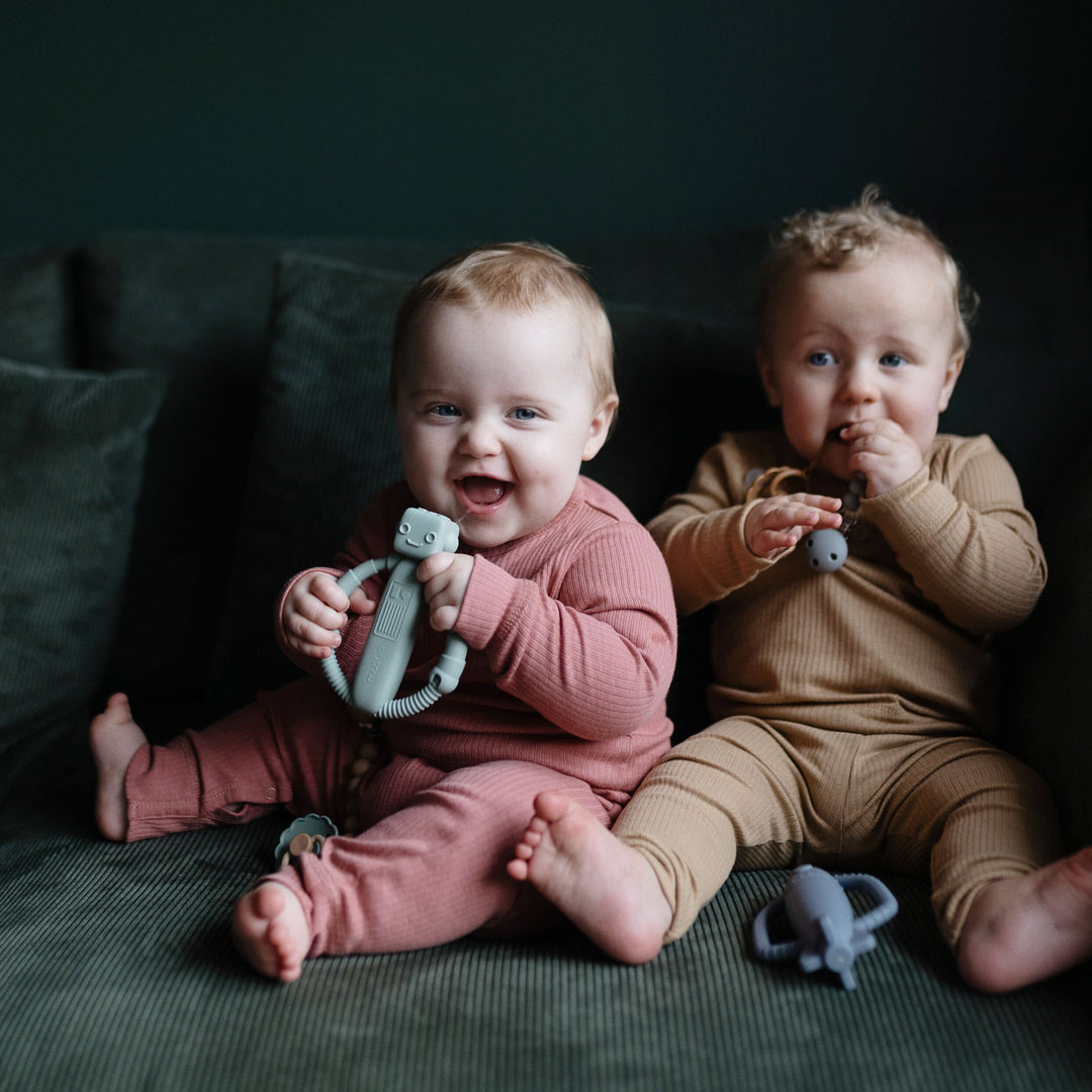 Babies playing with Mushie silicone rattle teethers