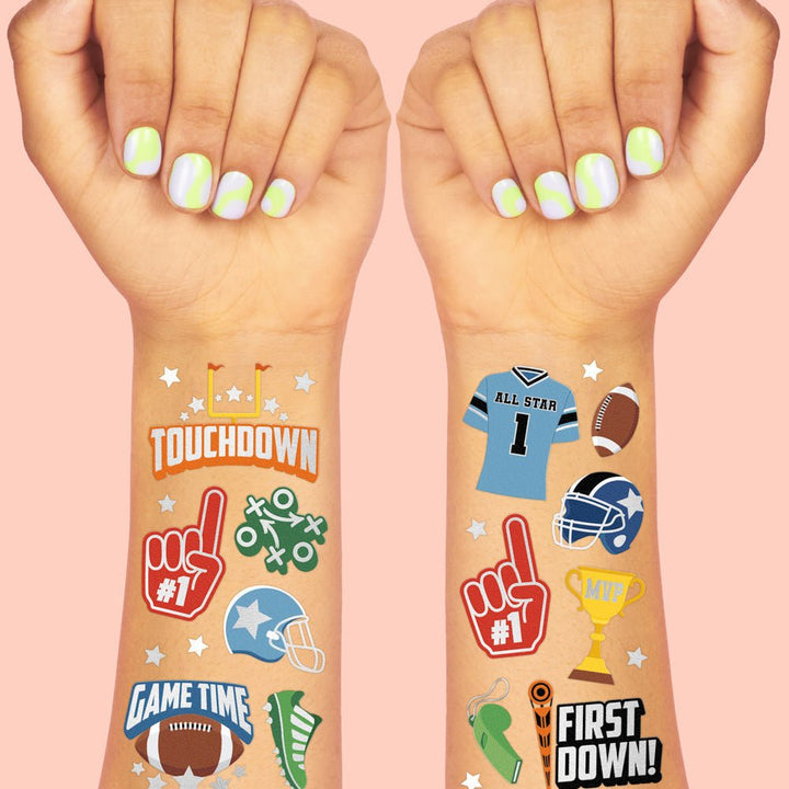 Football tattoos on two kids' forearms showing a foam finger, helmet, trophy, and First Down badge