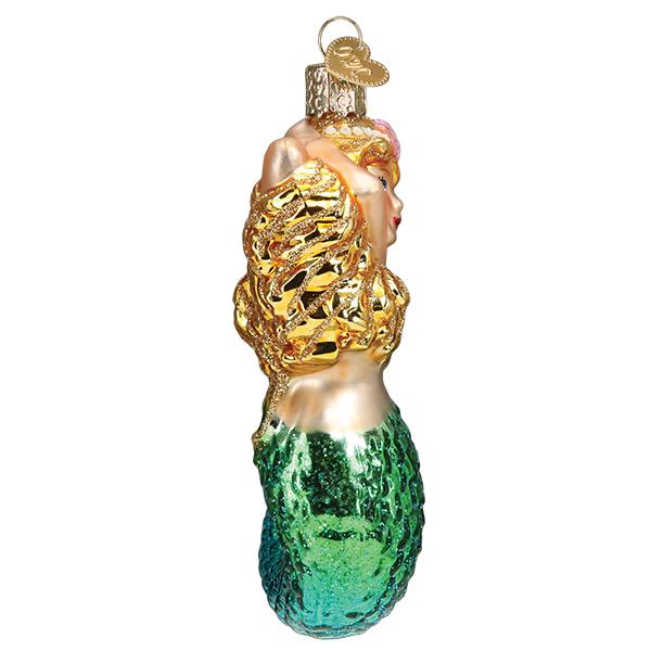Side view of the mermaid ornament with arms raised over her golden hair, on white