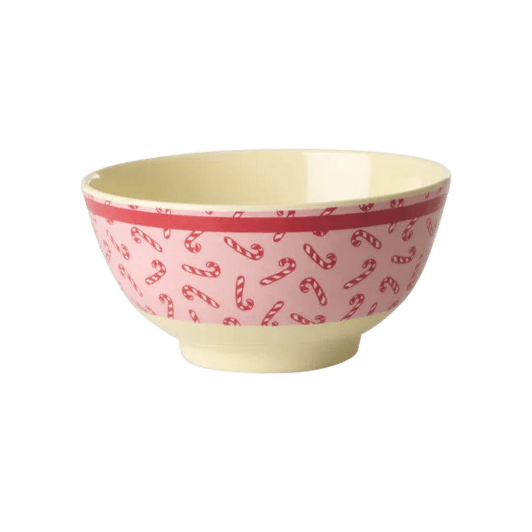 Medium pink melamine bowl with red and white candy canes, a red rim band, and cream interior, side view