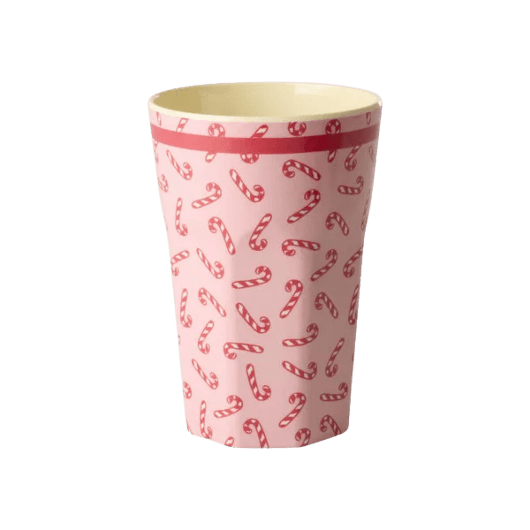 Tall pink melamine tumbler covered in red and white candy canes with a red stripe below the rim, front view