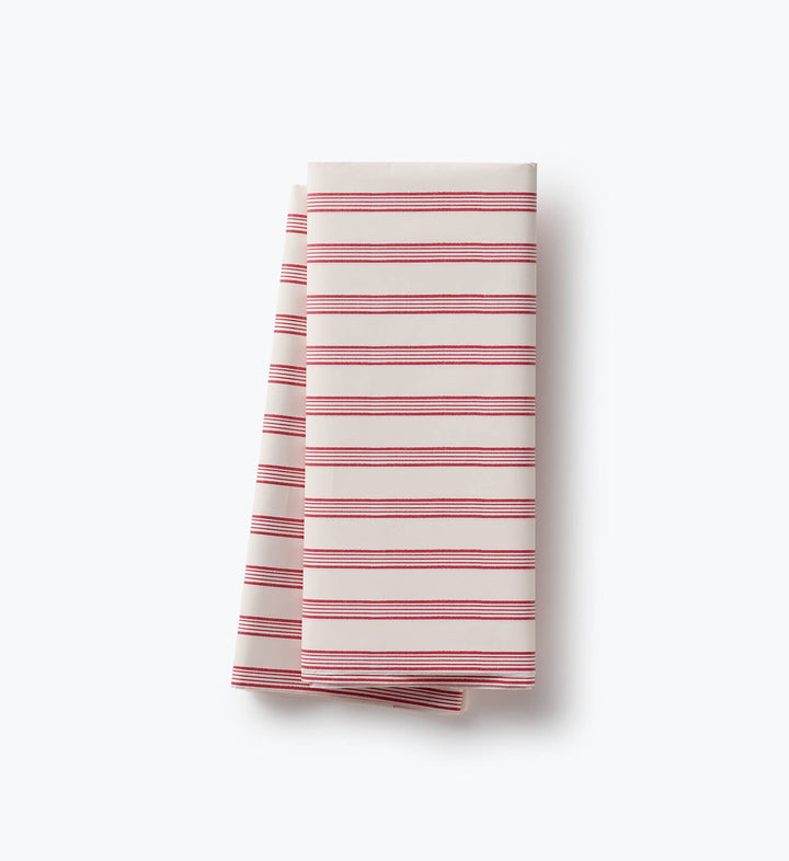Folded crimson and cream striped tissue paper sheets ready to line Christmas gift bags