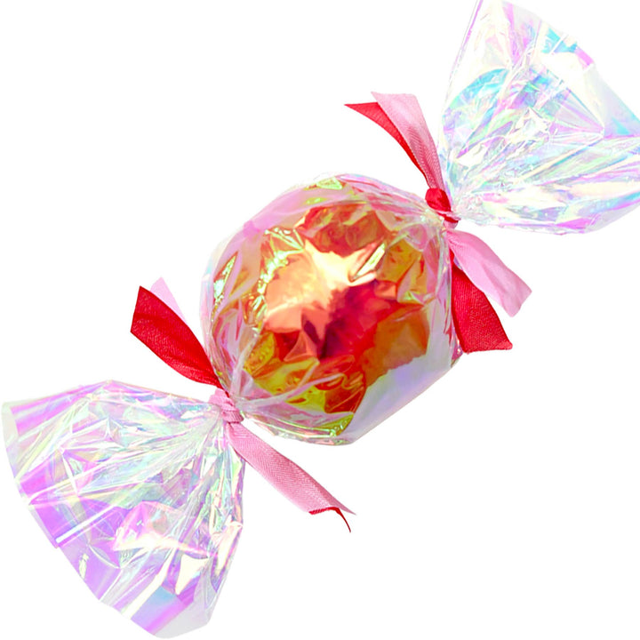 Copper foil bon bon surprise ball in iridescent cellophane tied with red and pink ribbons for New Year's Eve
