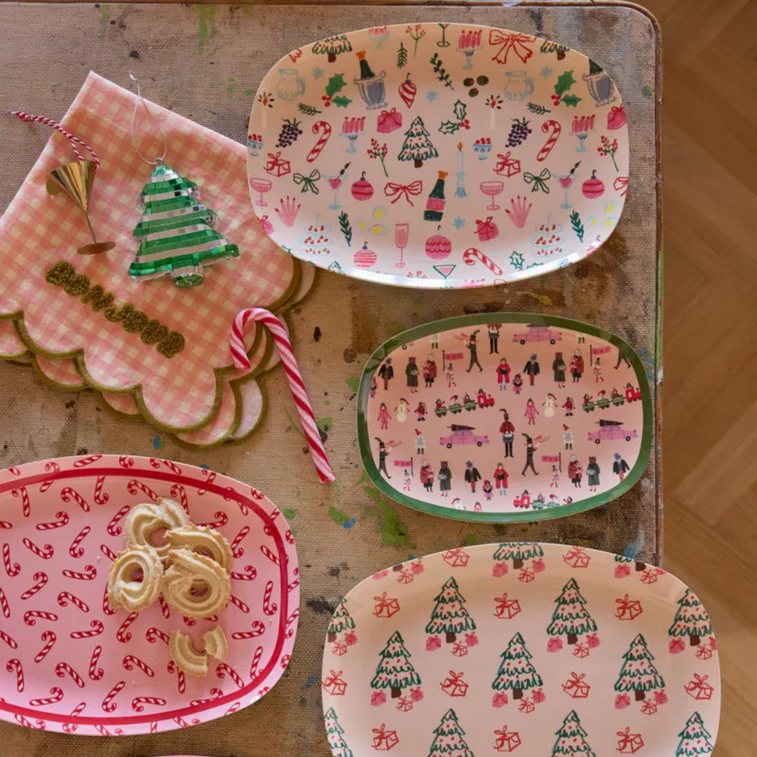 Candy cane plate of butter cookies with three other Rice Christmas plates, a candy cane, and a gingham napkin
