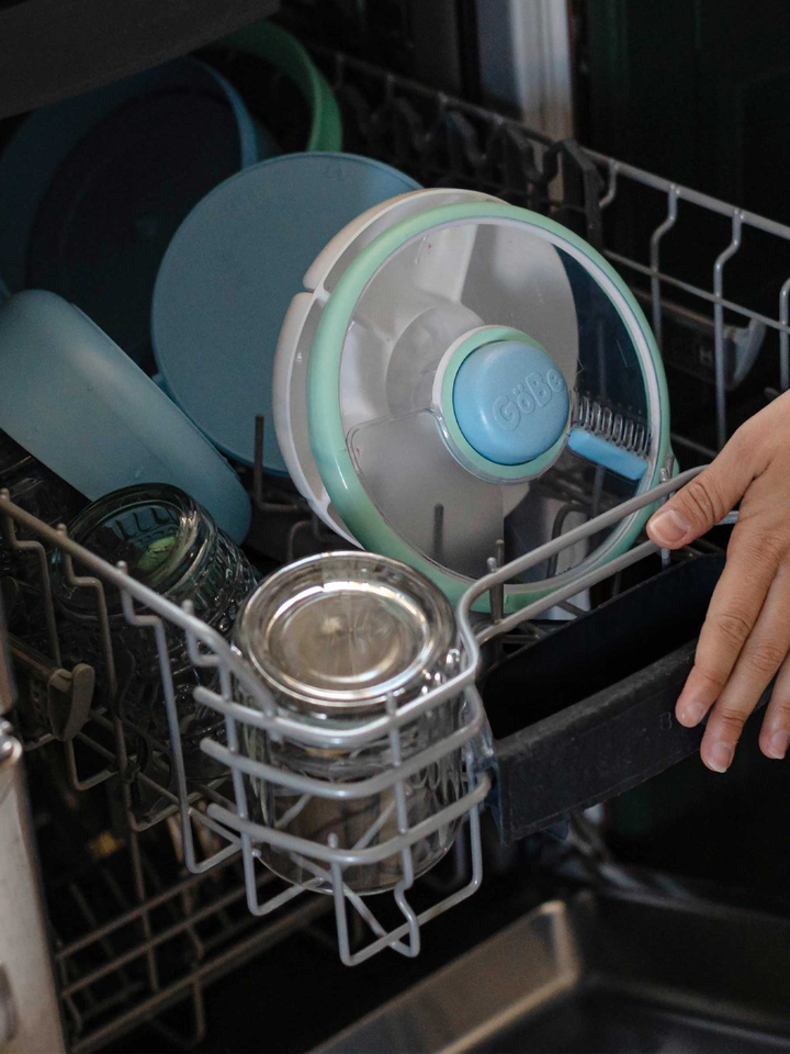 Blue Lunch Stack pieces loaded on the top rack of a dishwasher