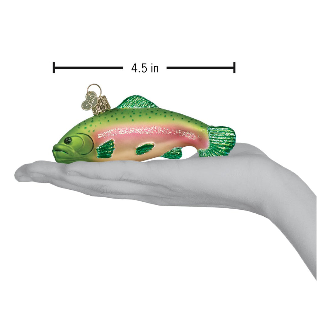 Rainbow trout ornament resting on an open hand with a 4.5 inch scale marker above the fish