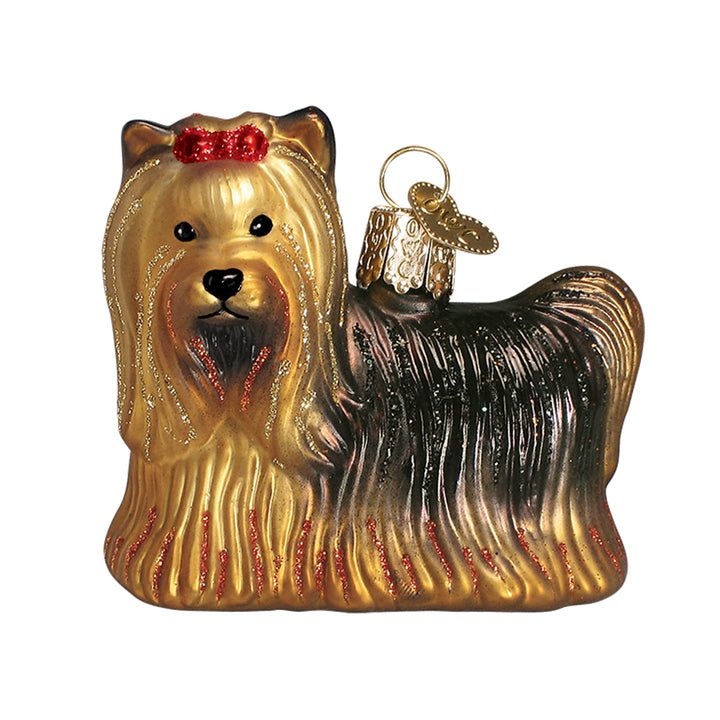 Tan and black Yorkie ornament with a red bow topknot and long silky coat, three-quarter front view