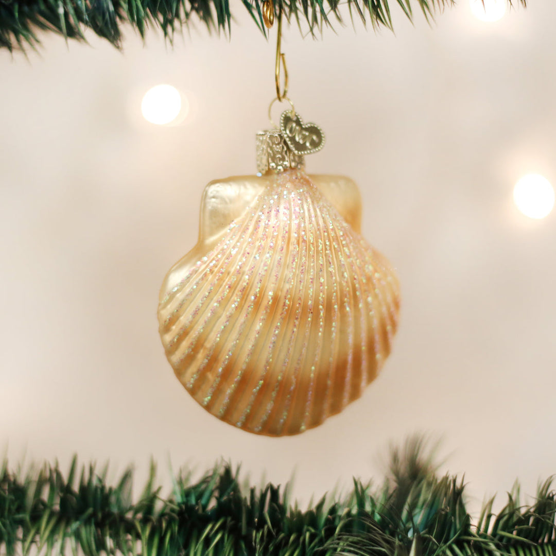 Scallop shell ornament hanging on a lit Christmas tree with soft bokeh lights