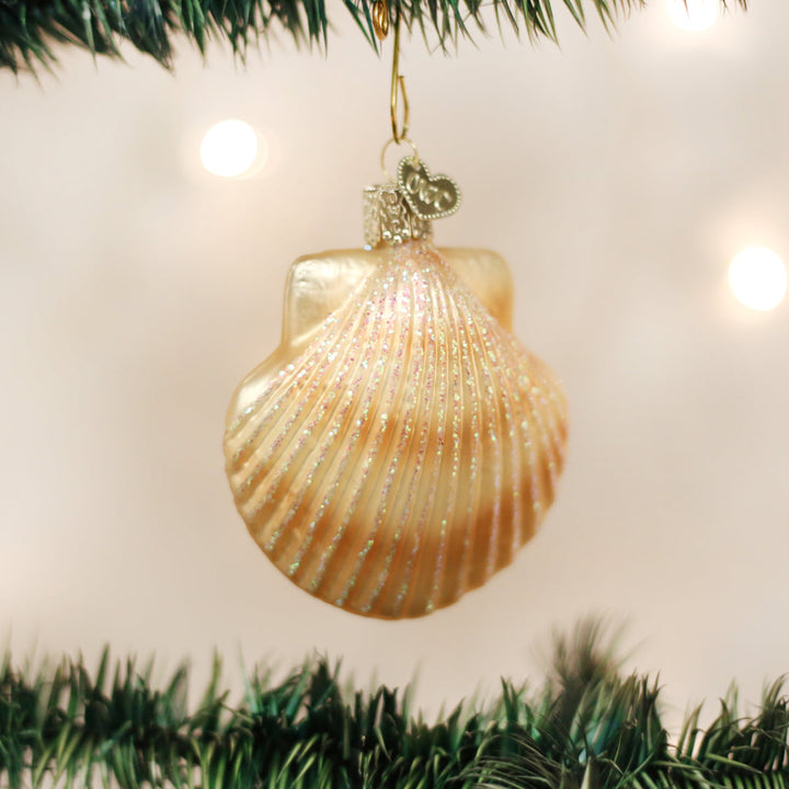 Scallop shell ornament hanging on a lit Christmas tree with soft bokeh lights