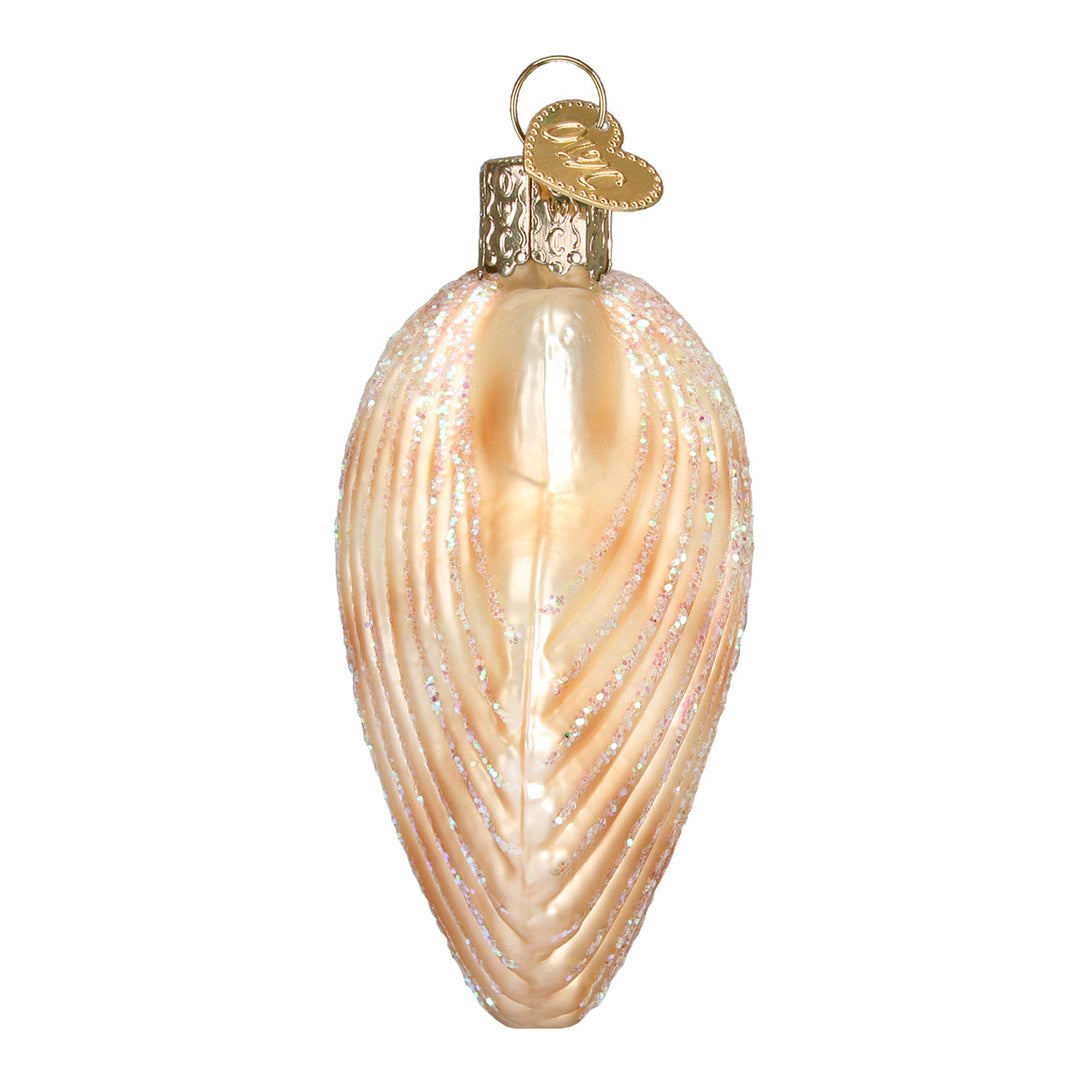 Side view of the scallop shell ornament showing its curved peach profile, on white