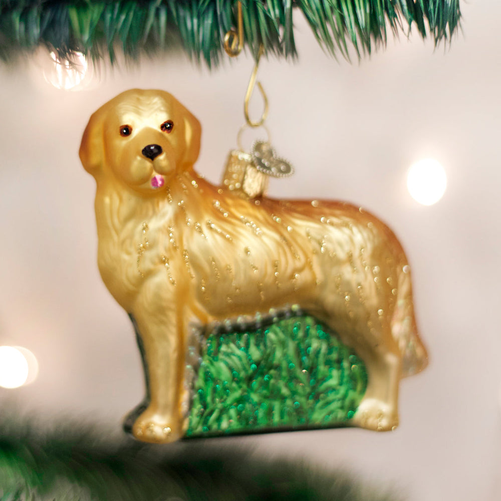 Golden retriever glass ornament hanging on a twinkling Christmas tree with warm bokeh lights