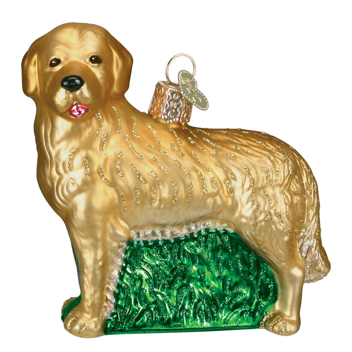 Golden retriever ornament in hand-painted gold glass standing on glittered green grass, three-quarter front view
