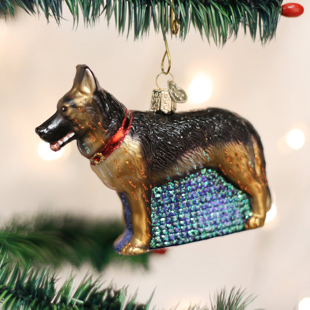 German Shepherd glass ornament hanging on a Christmas tree with twinkling lights