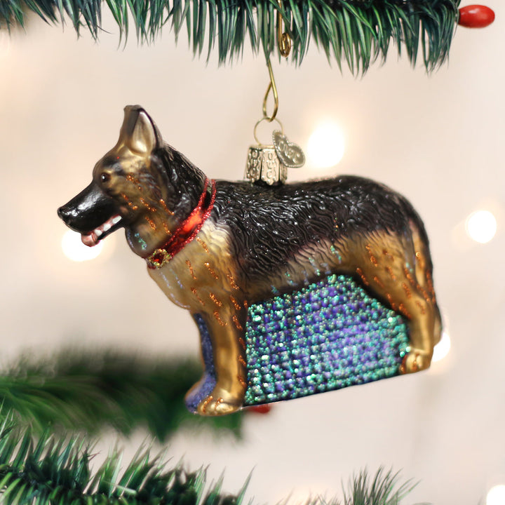 German Shepherd glass ornament hanging on a Christmas tree with twinkling lights