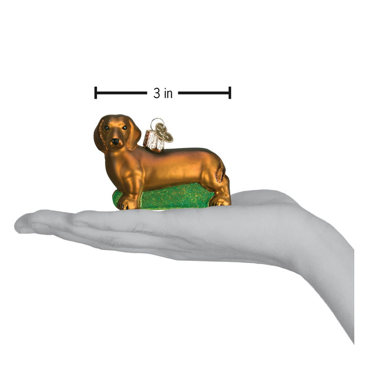 Dachshund ornament on an open palm with a 3 inch width marker for scale
