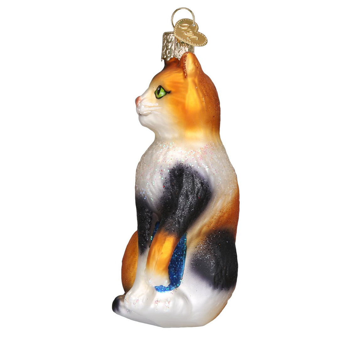 Calico cat ornament in side profile showing orange and black patches and a white chest
