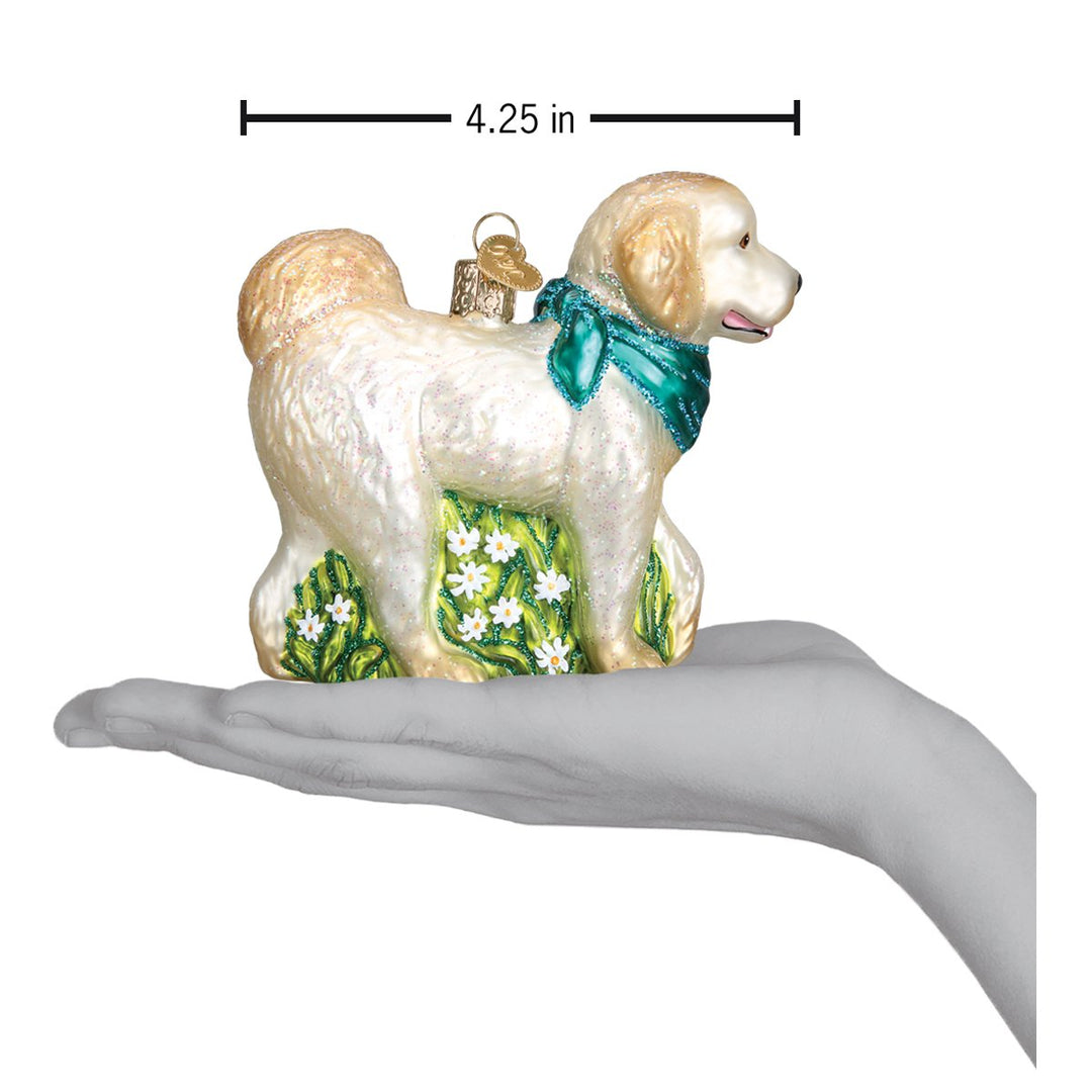 Doodle dog ornament on an open palm with a 4.25 inch width marker for scale