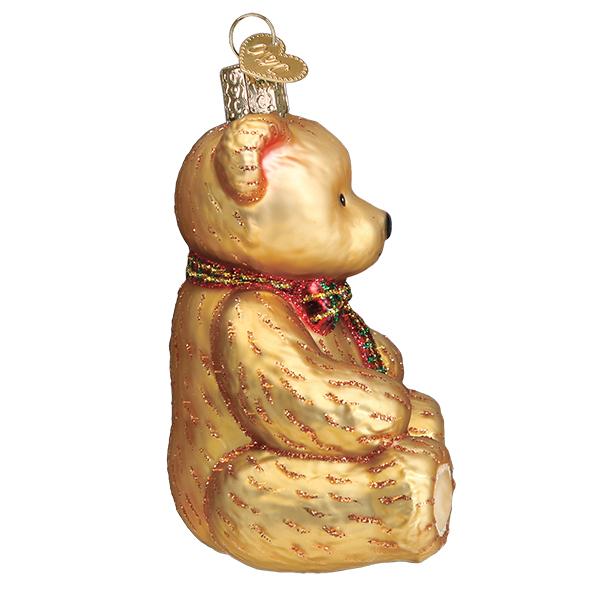 Side profile of the seated teddy bear ornament showing its round ears and black nose, on white