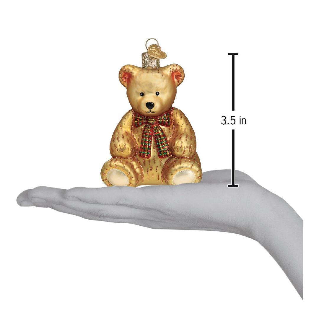 Teddy bear ornament on an open palm beside a 3.5 inch height marker